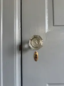 Blue painted 1924 Door with copper key escutcheon and brass patinated door hardware with glass knob