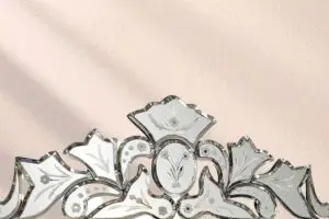 rnate Venetian etched glass mirror crest detail against warm plaster wall — vintage home interior mirror for old houses