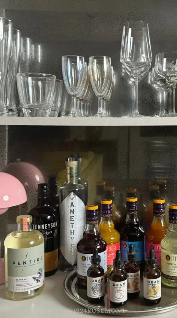 foxed mirror backsplash in shelving with vintage bar and barware
