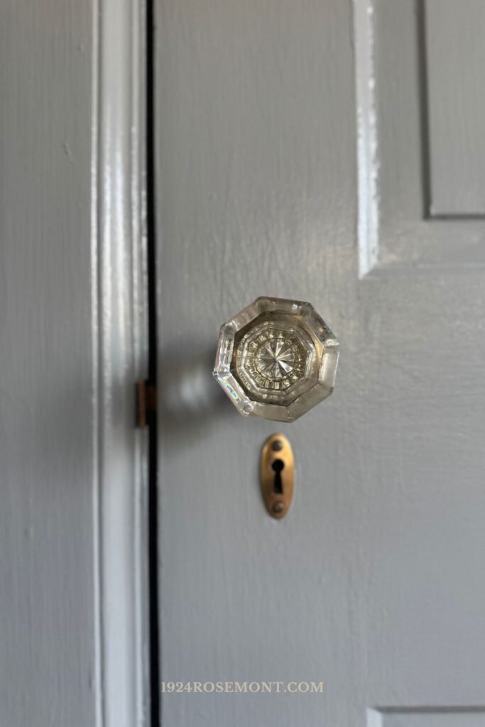 Master bedroom blue gray door with original glass antique doorknob key escutcheon and strikeplate after restoration