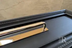 Polished nickel traditional drawer pull with modern clean-lined backplate on matte black vanity drawer