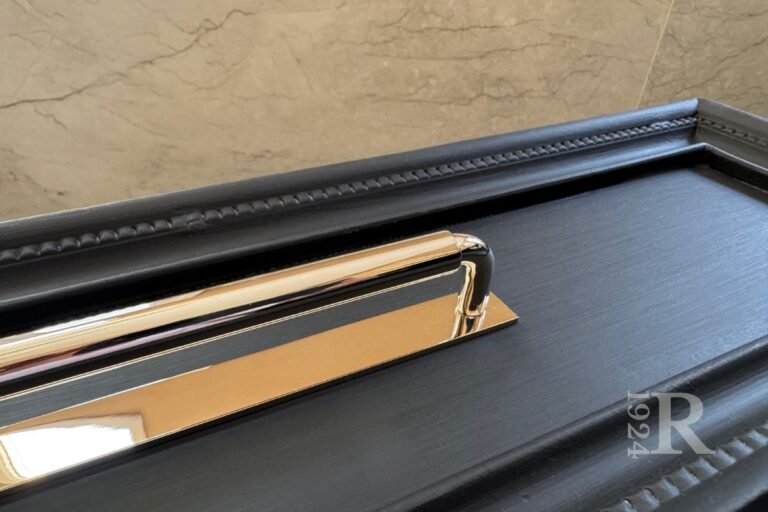 Polished nickel traditional drawer pull with modern clean-lined backplate on matte black vanity drawer