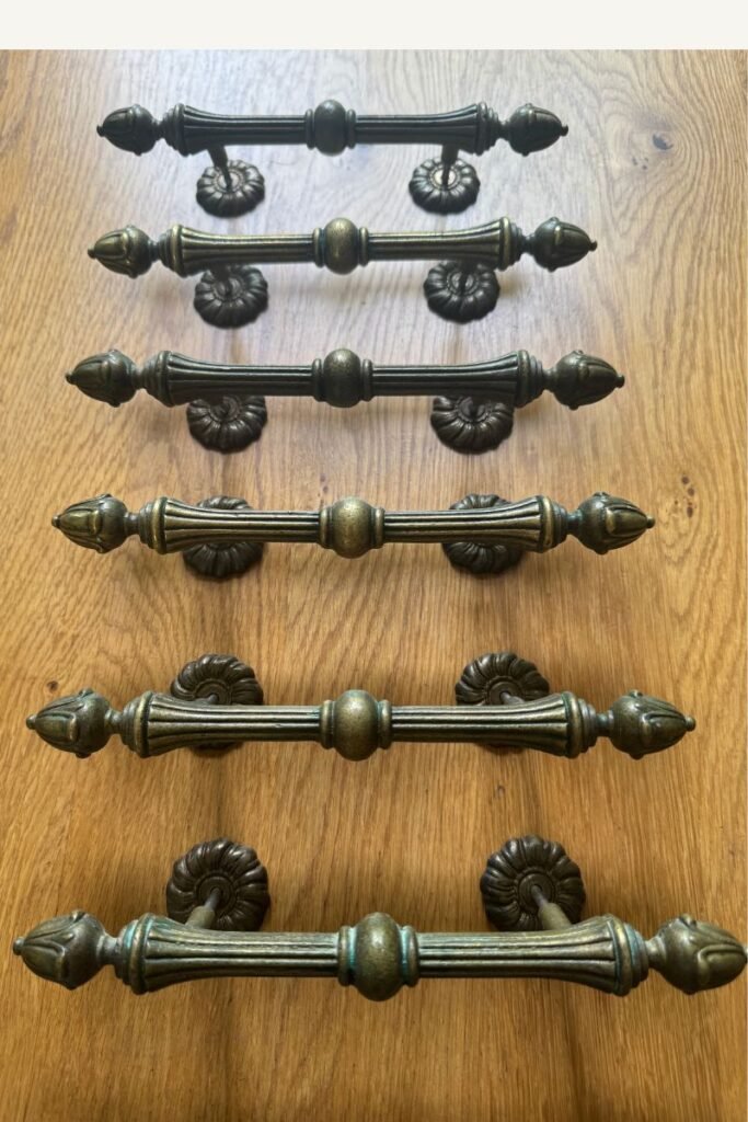 Vintage brass ornate drawer pulls with considerable patina on wood countertop